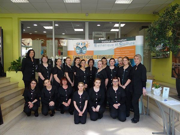 Un groupe de personnes en uniforme noir pose devant une banderole.