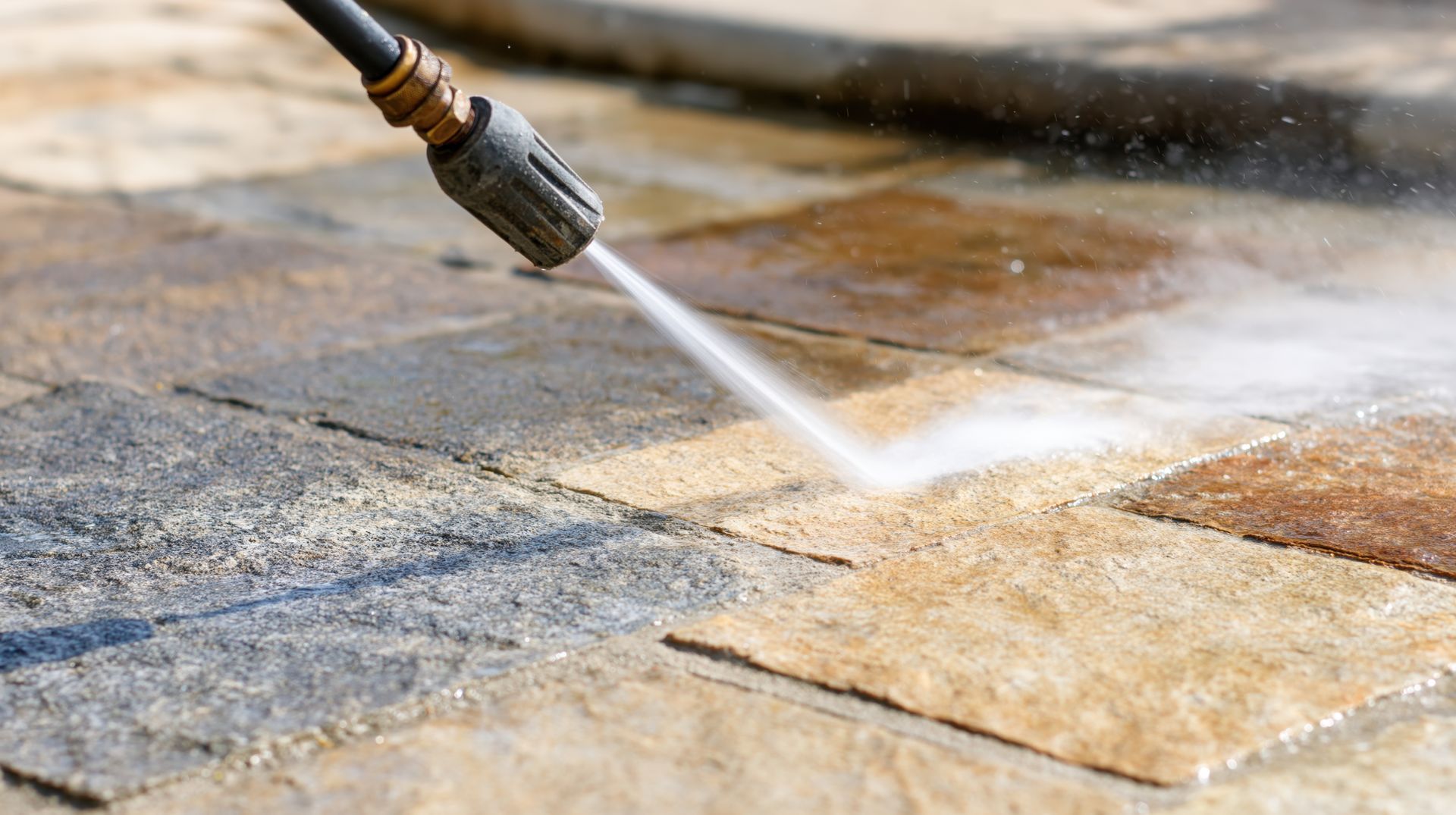 Un nettoyeur à haute pression projette de l’eau sur une terrasse en pierre
