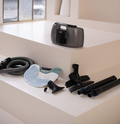 A vacuum cleaner is sitting on a white shelf next to a window