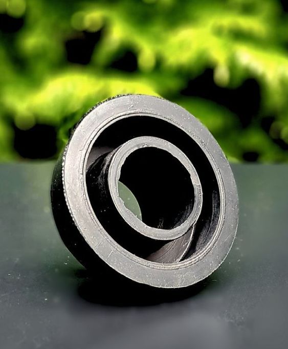 A black ring with a hole in the middle is sitting on a table.
