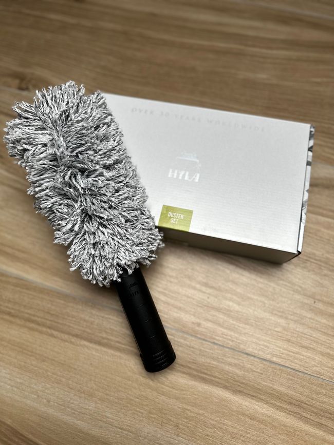 A brush is sitting on a wooden table next to a box