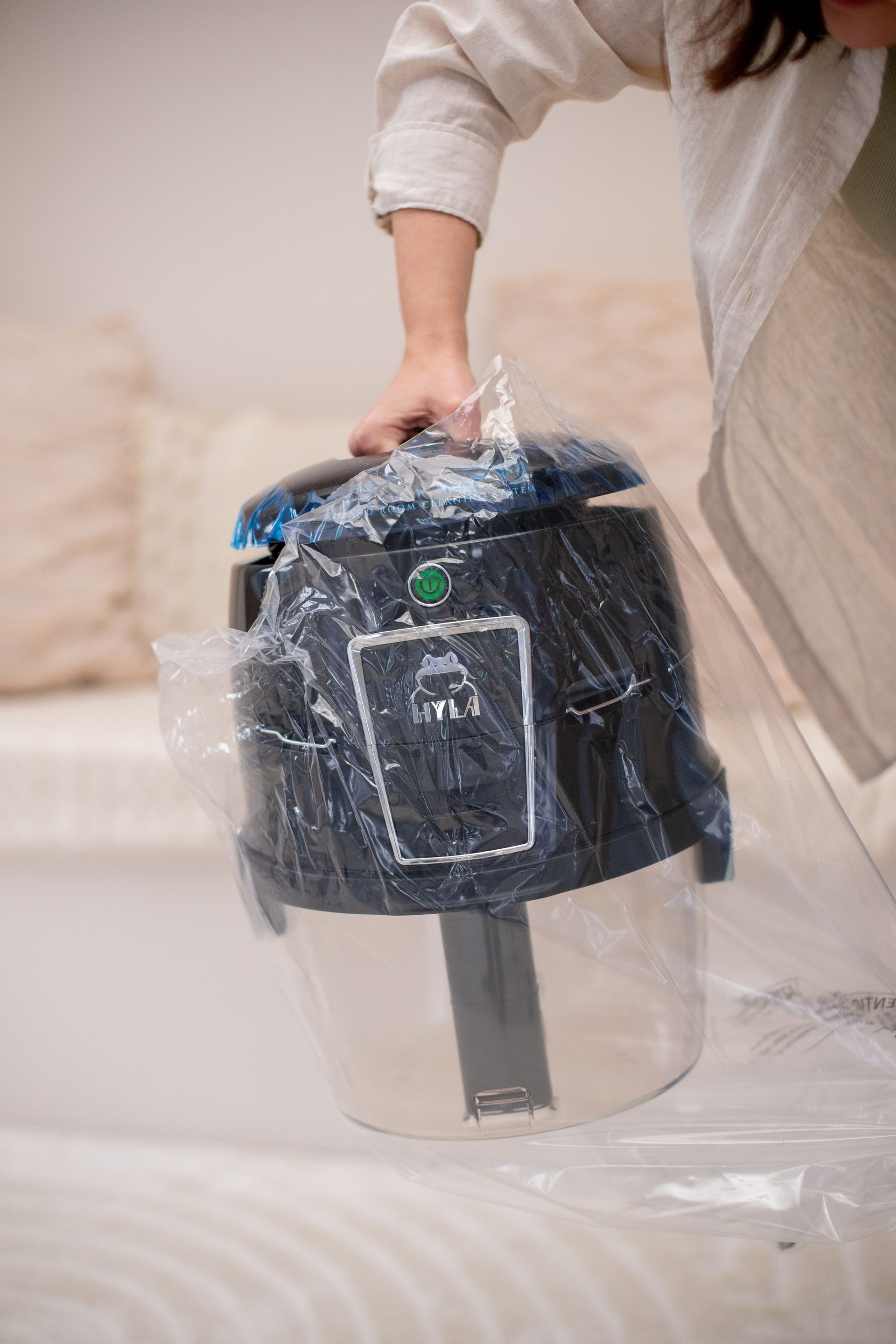 A person is holding a vacuum cleaner in a plastic bag.