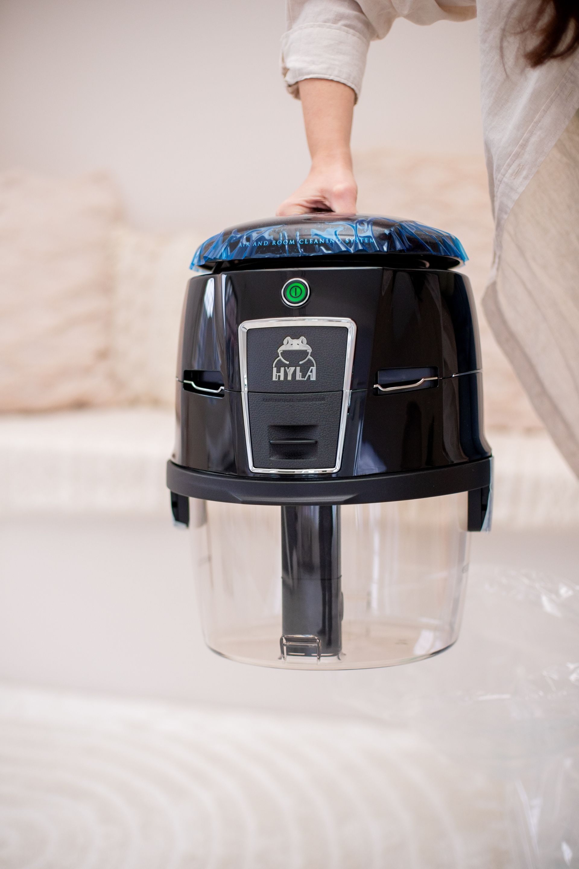 A person is holding a vacuum cleaner in their hand.
