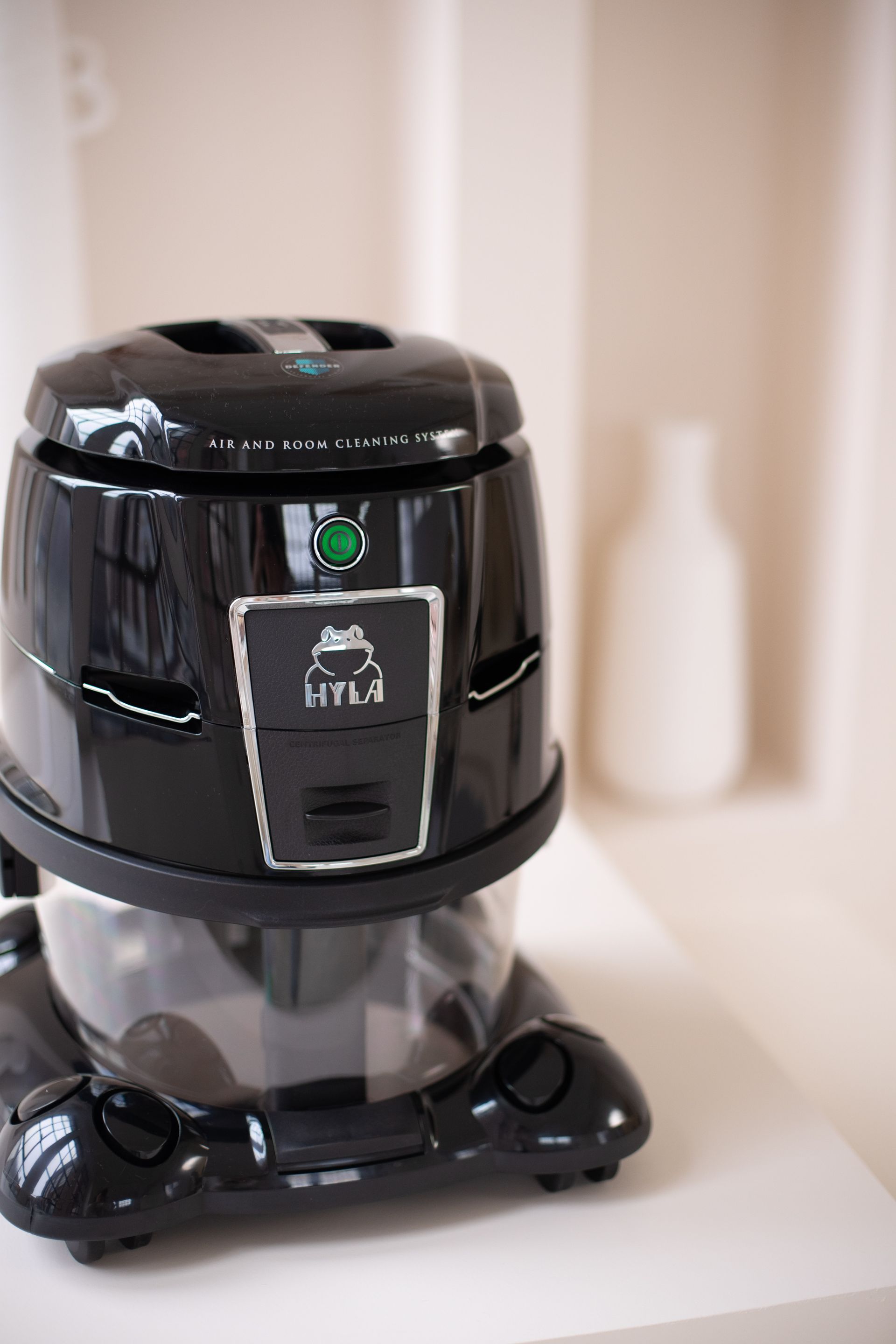 A black vacuum cleaner is sitting on a white table