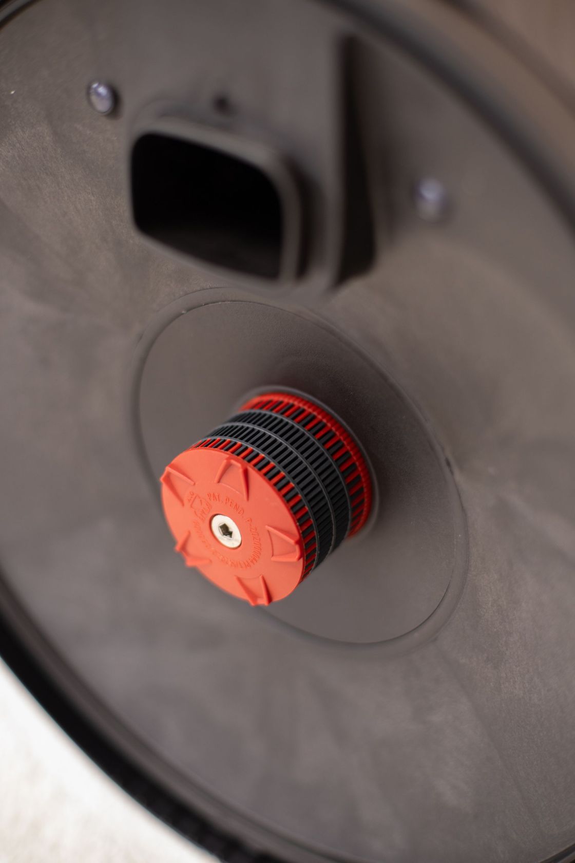 A close up of the inside of a vacuum cleaner with a red filter.