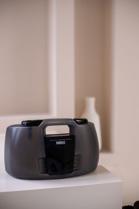 A radio is sitting on a white table next to a vase.