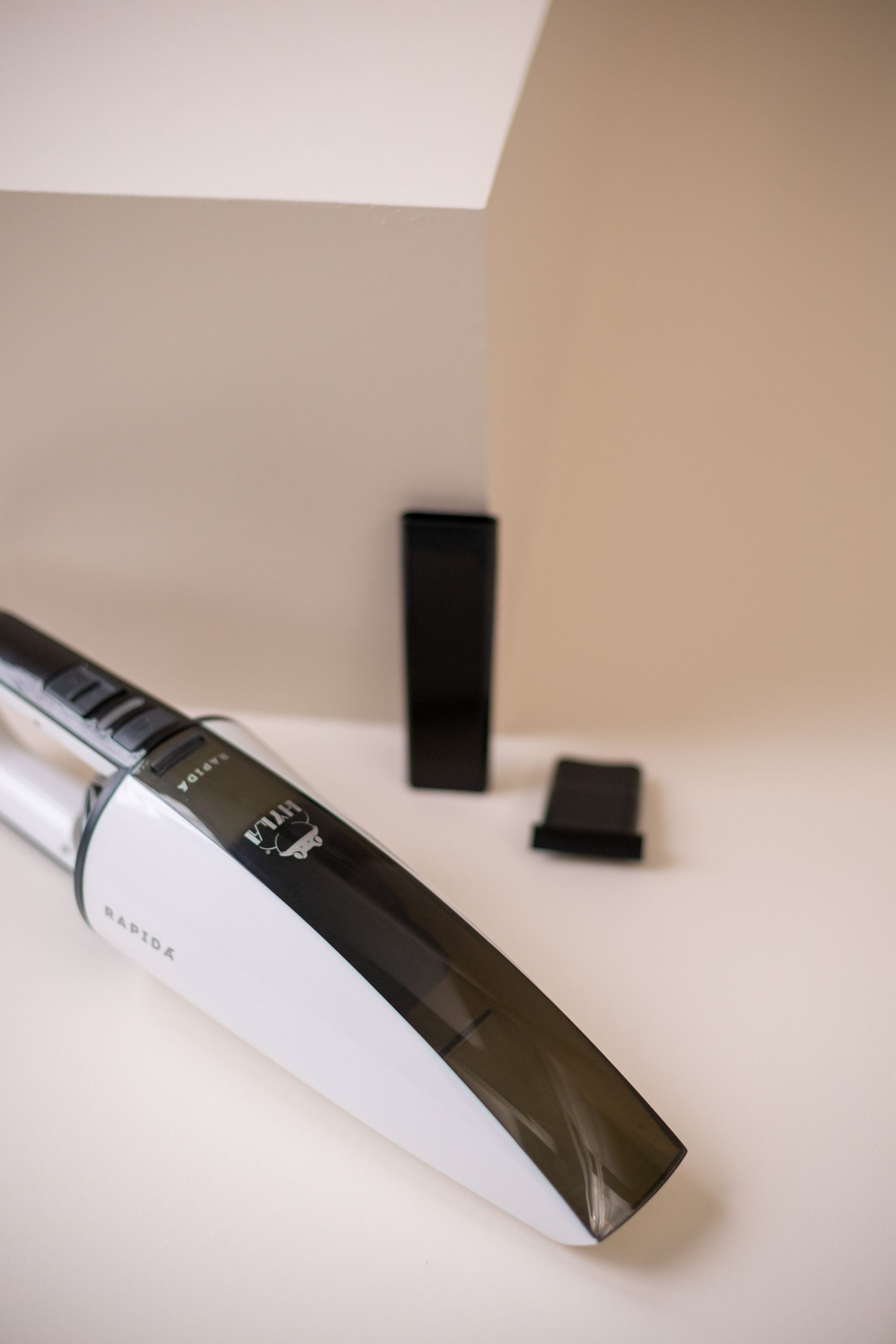 A white and black handheld vacuum cleaner is sitting on a table