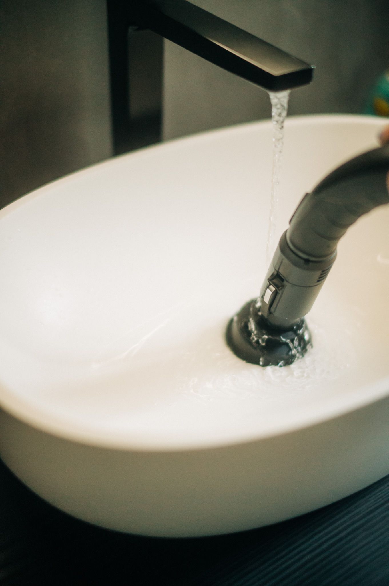 A person is washing their hands in a bathroom sink.
