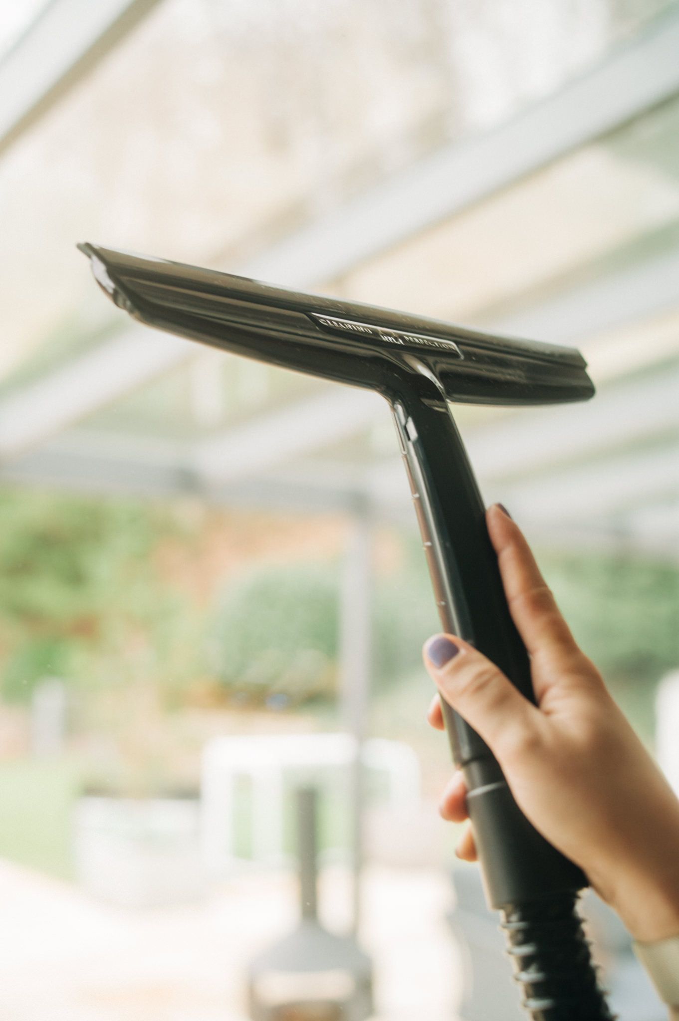 A person is cleaning a window with a squeegee.