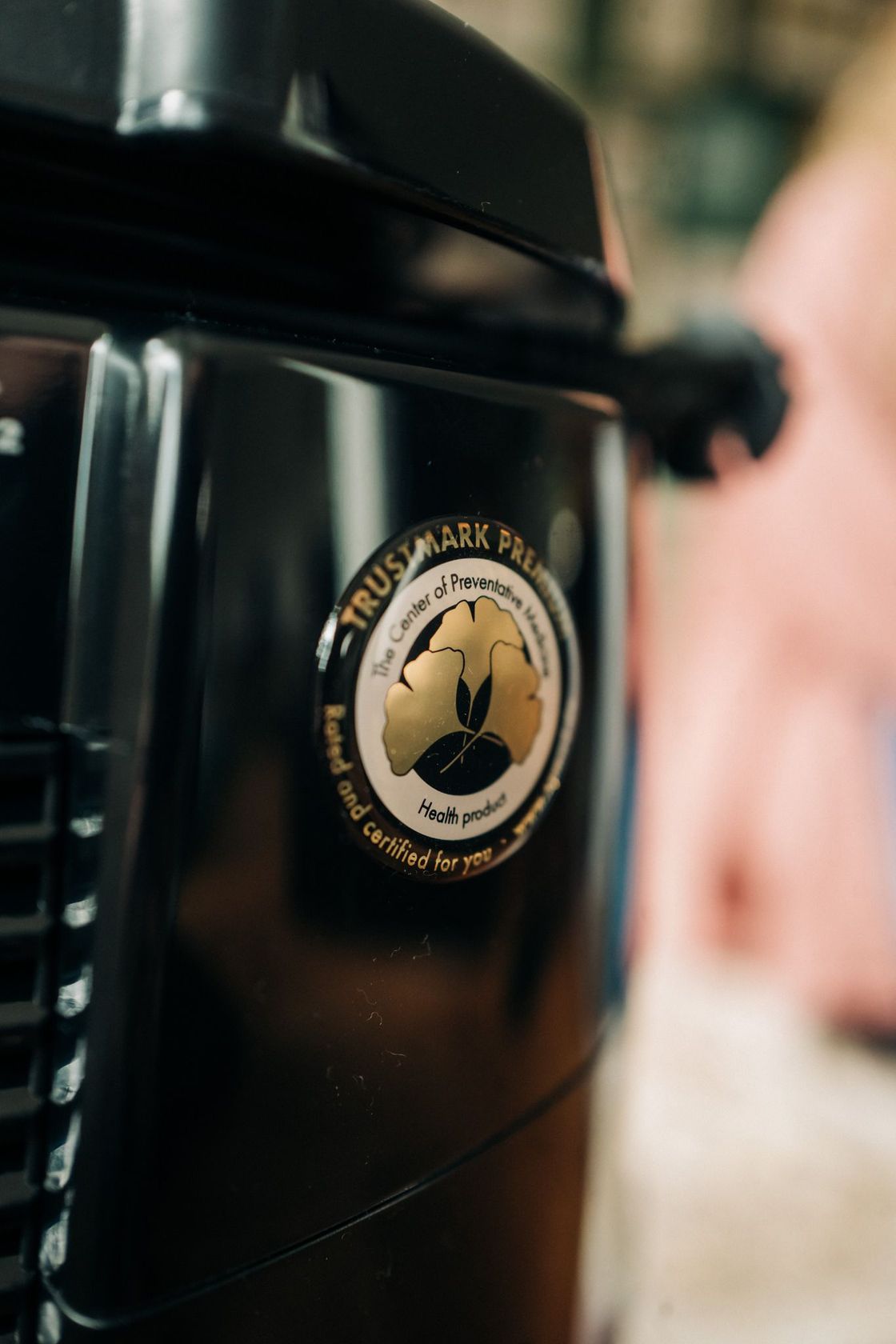 A close up of a black blender with a logo on it