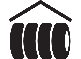 Cuatro neumáticos apilados bajo un techo, probablemente para almacenamiento.