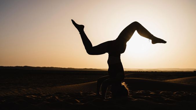 Telas de colores secándose en un tendedero en un pueblo del desierto con montañas al fondo.