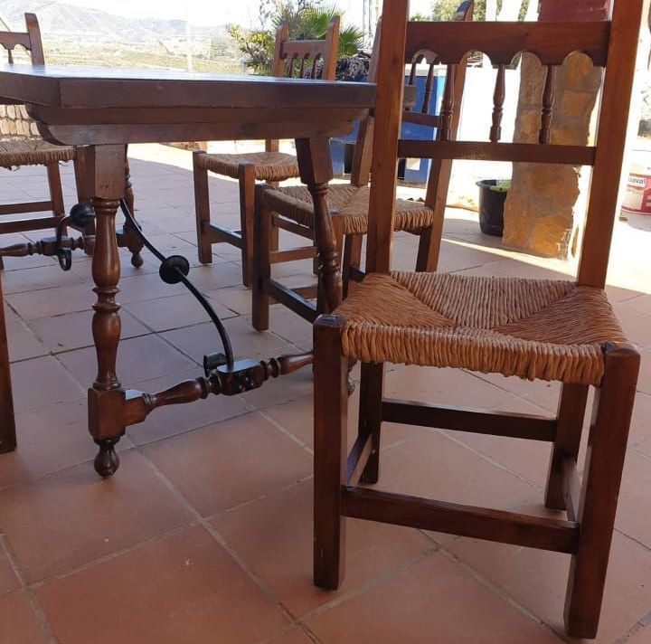 Una silla de madera se encuentra junto a una mesa de madera.