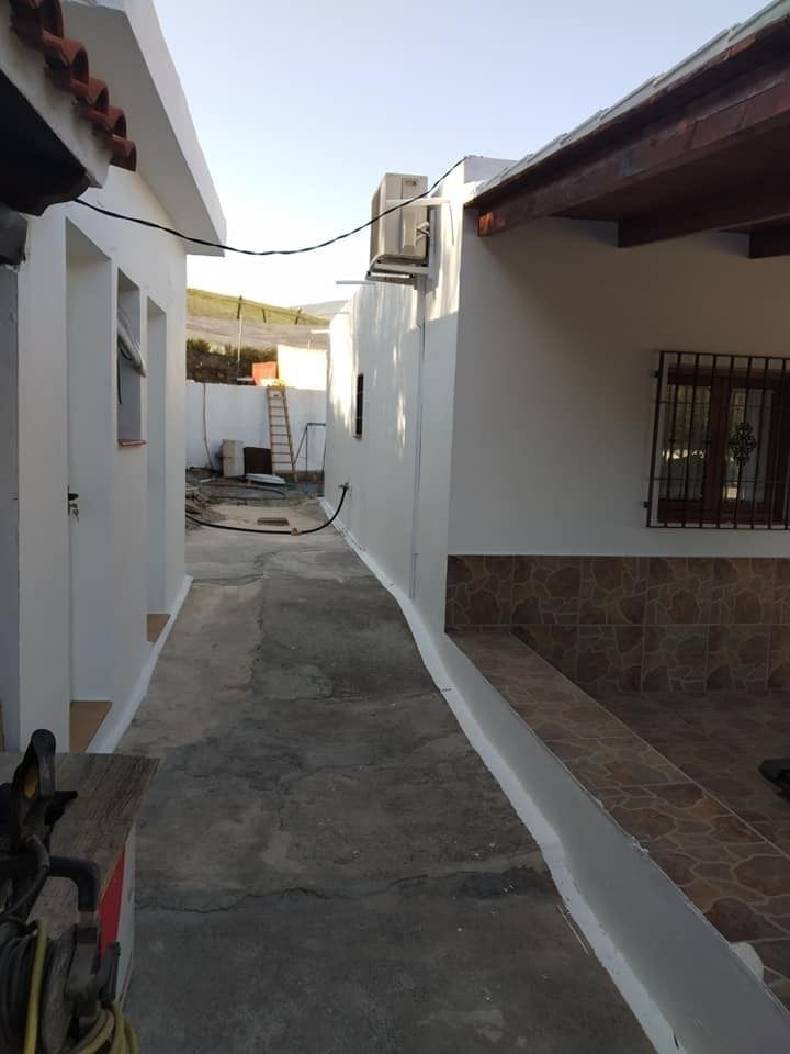 Un callejón estrecho entre dos edificios blancos