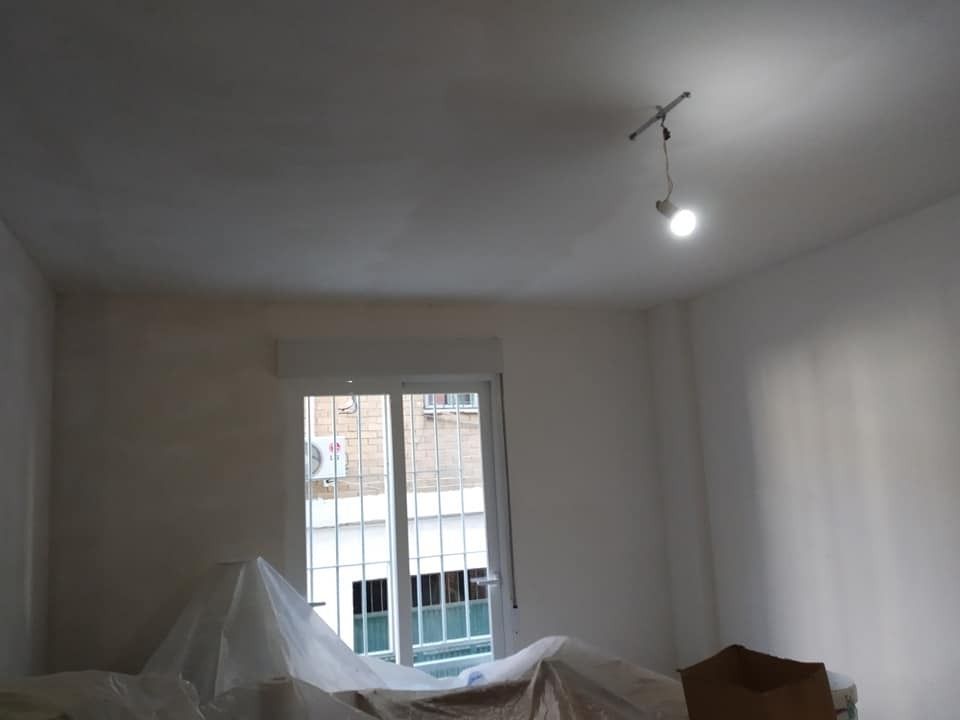 Una habitación con una ventana y una luz en el techo