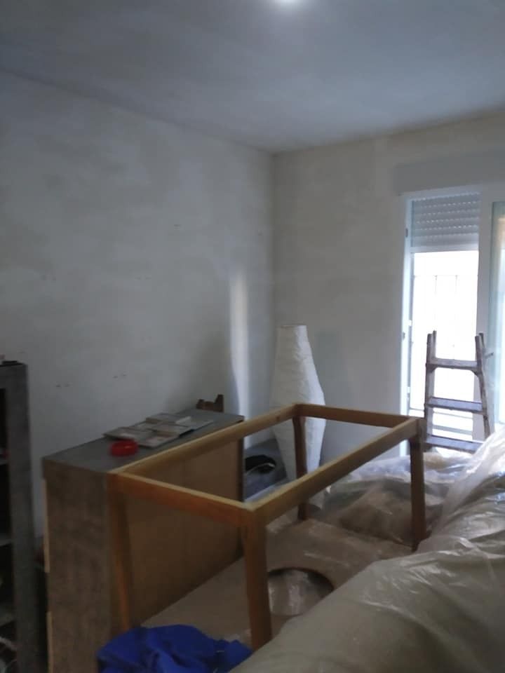 Una habitación con una mesa y una escalera dentro.