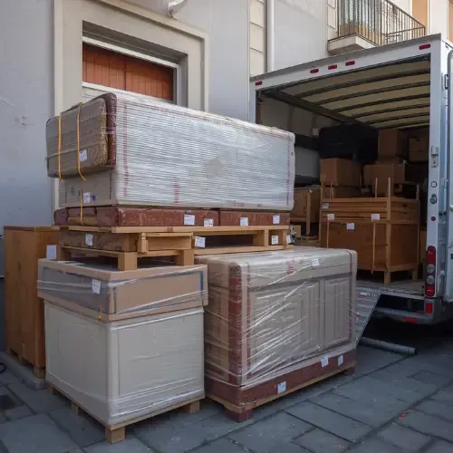 Loaded truck and pallets of boxed goods outside a building