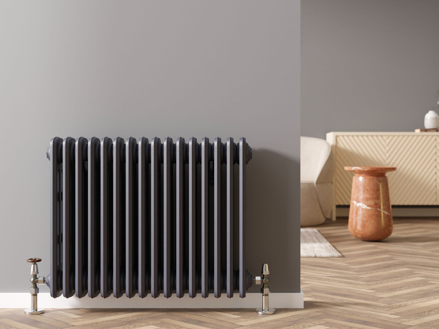 Radiateur gris foncé sur un mur gris, près d'une table d'appoint et de meubles clairs sur un parquet.