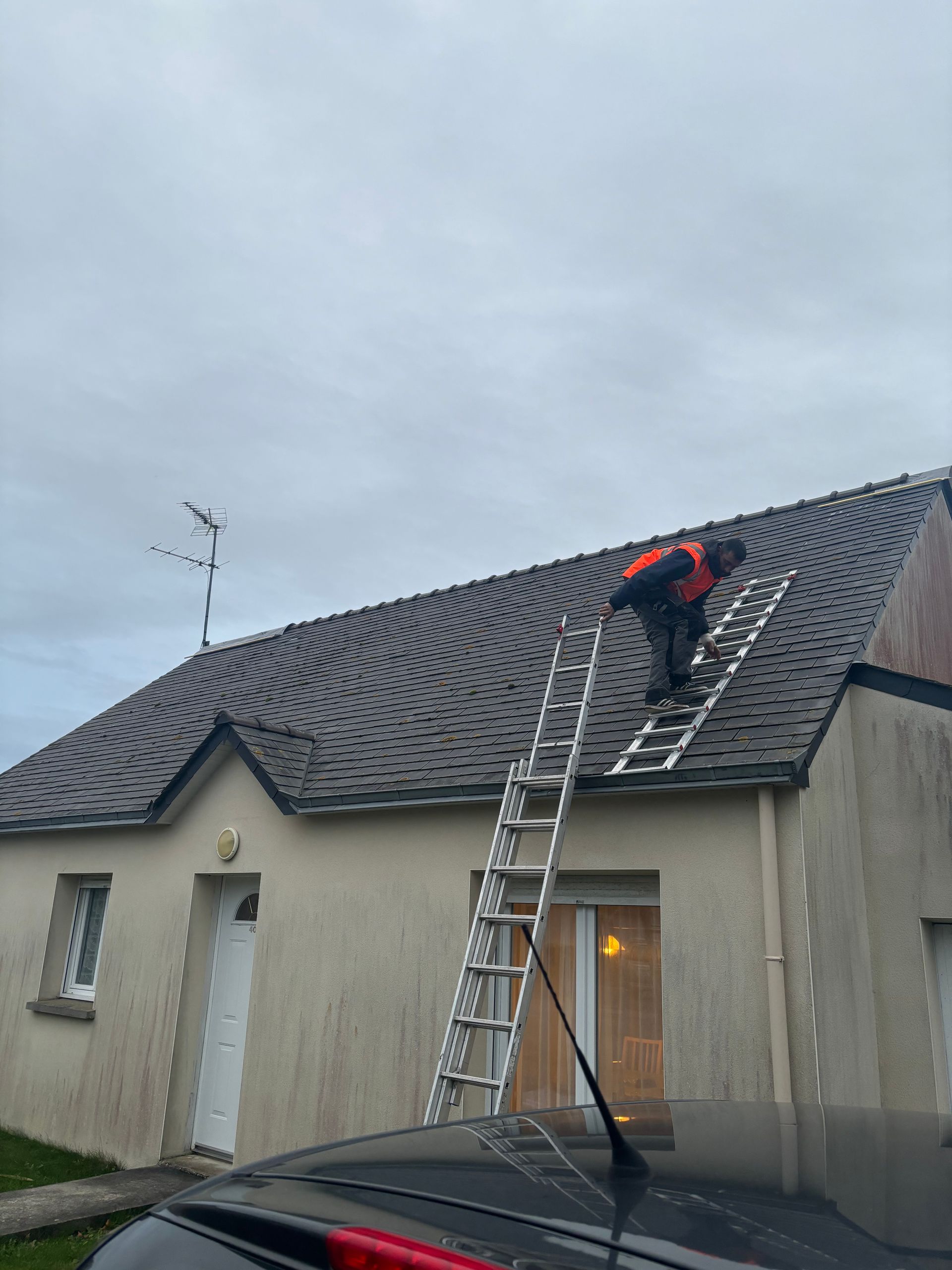 Couvreur montant sur un toit avec une échelle