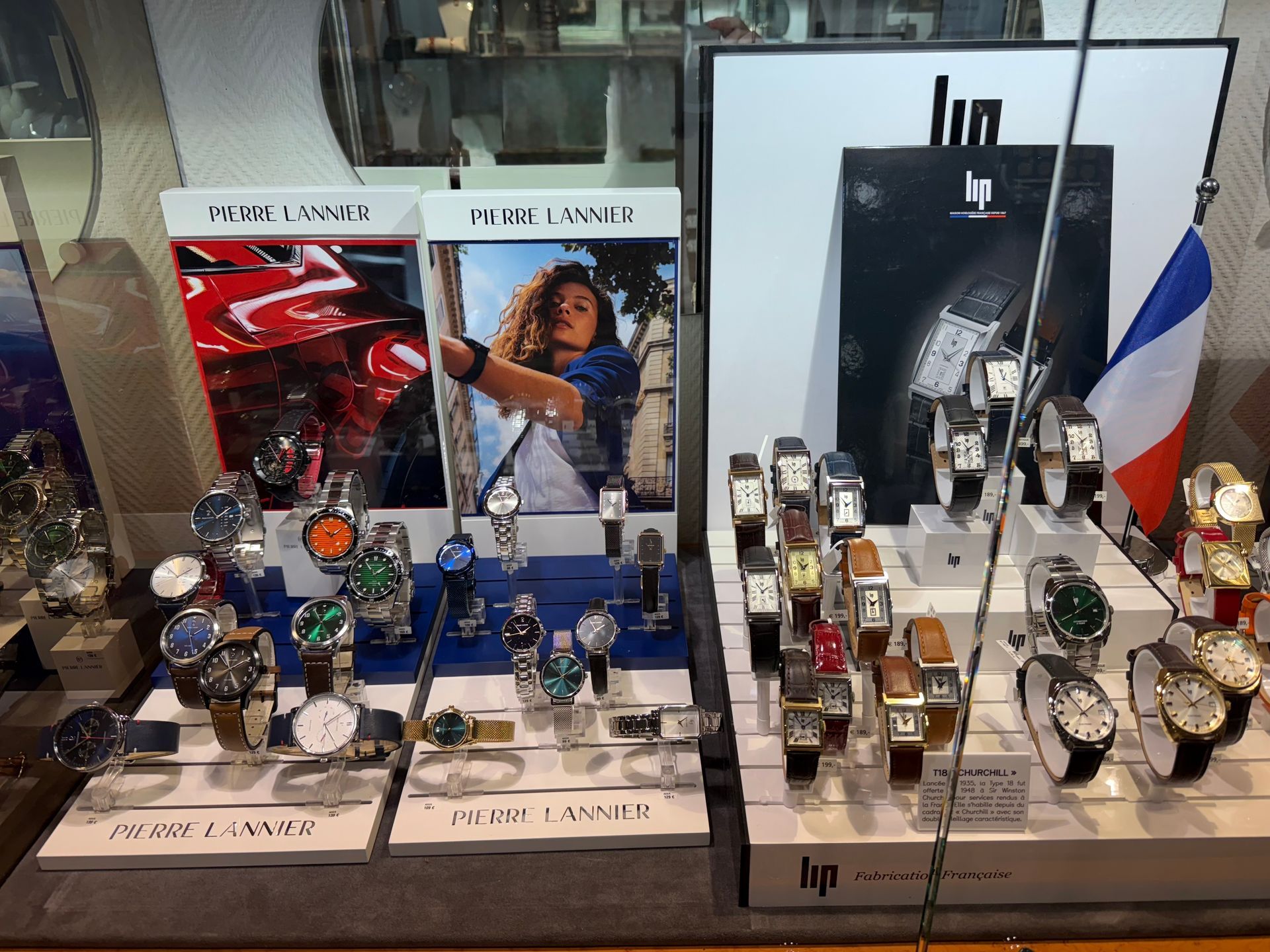 Personne portant des gants noirs tenant une montre en or dans une vitrine.