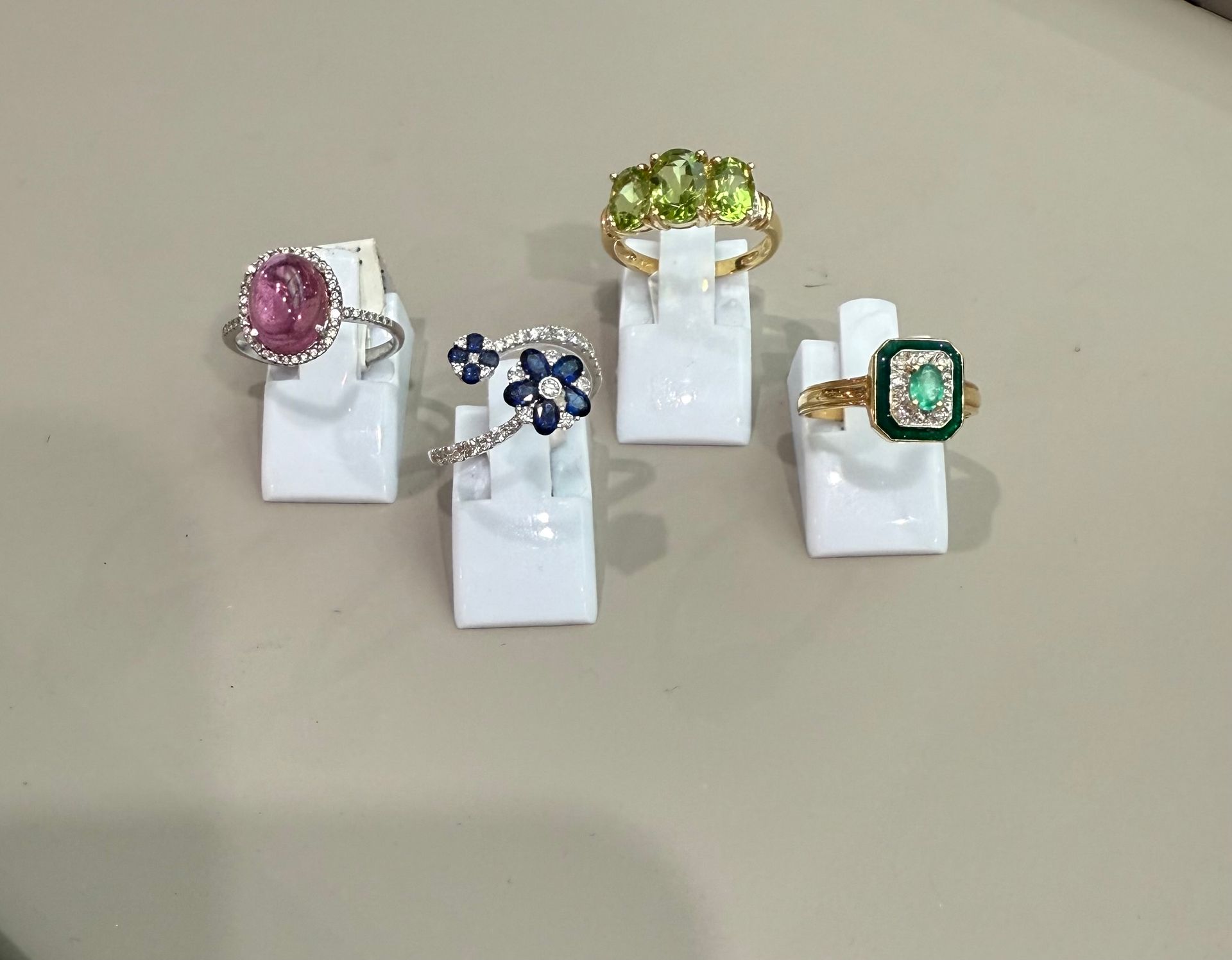 Une main utilisant une pince très fine pour sertir un diamant dans une bague en or, gros plan.