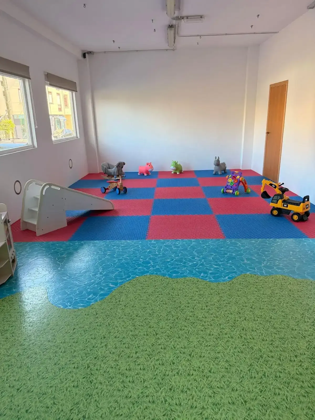 Pequeña sala de juegos con coloridas colchonetas de espuma