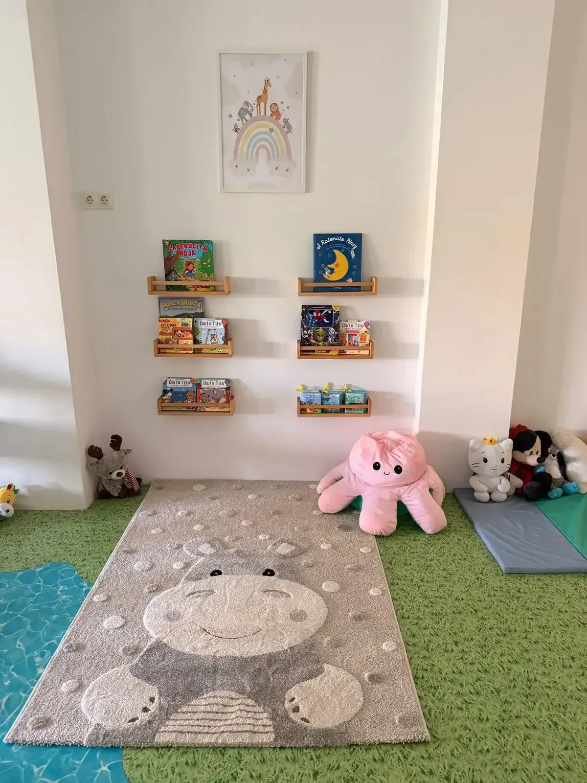 Zona de juegos infantiles con estanterías en la pared, juguetes