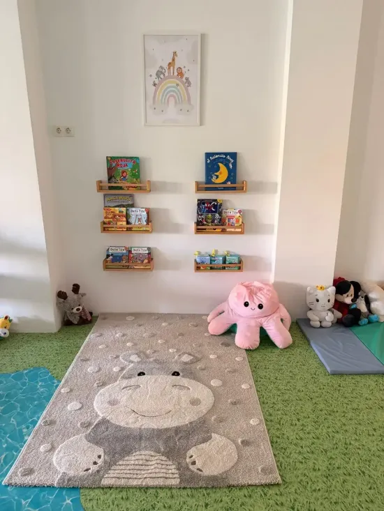 Zona de juegos infantiles con estanterías en la pared, juguetes