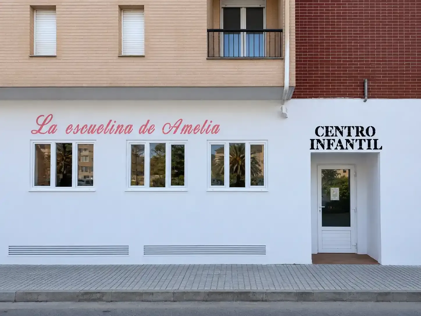 Fachada del edificio de la guardería “La Estrellita de Amalia” y “Centro Infantil” con ventanas y entrada.
