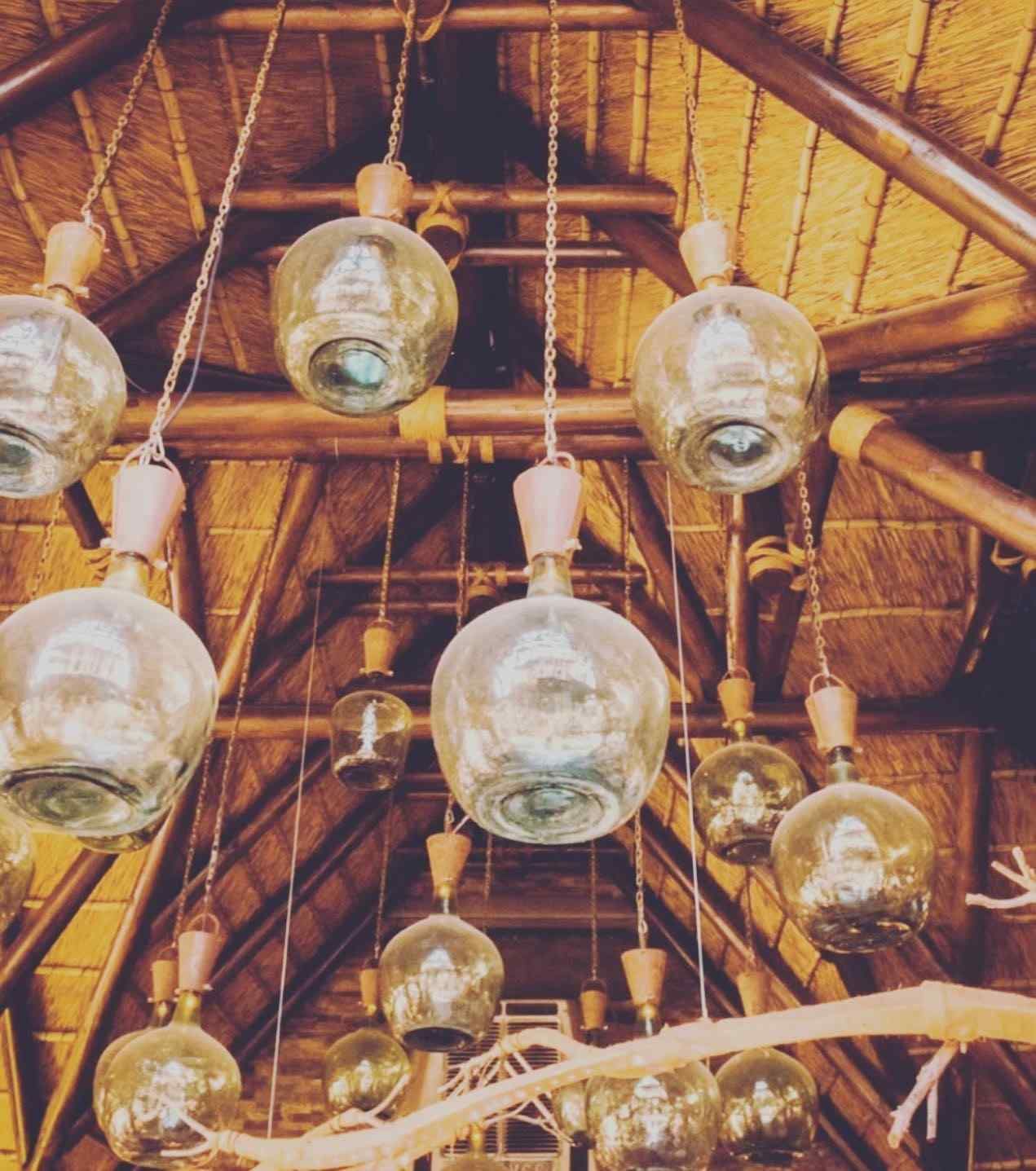 Lámparas de globo de cristal colgando de un techo de paja.