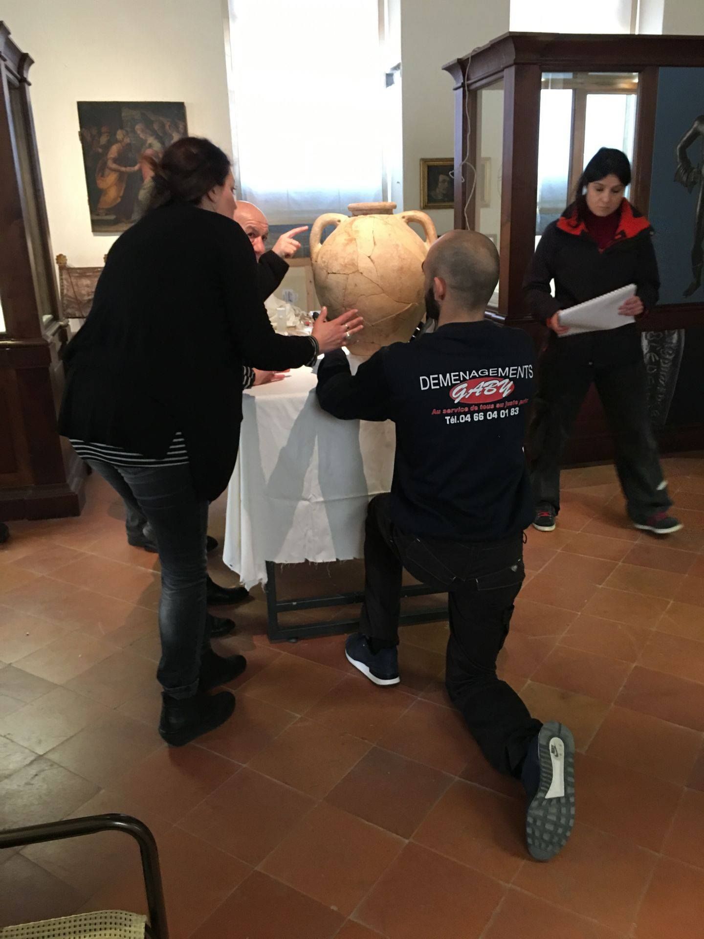 Équipe de déménageurs qui s'apprête à emballer une jarre dans un musée