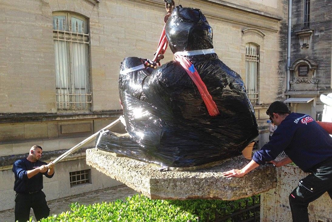 Deux déménageurs qui déplacent une œuvre d'art emballée