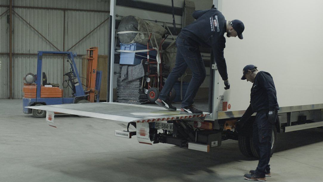 Deux déménageurs qui finissent de charger un camion dans un entrepôt 