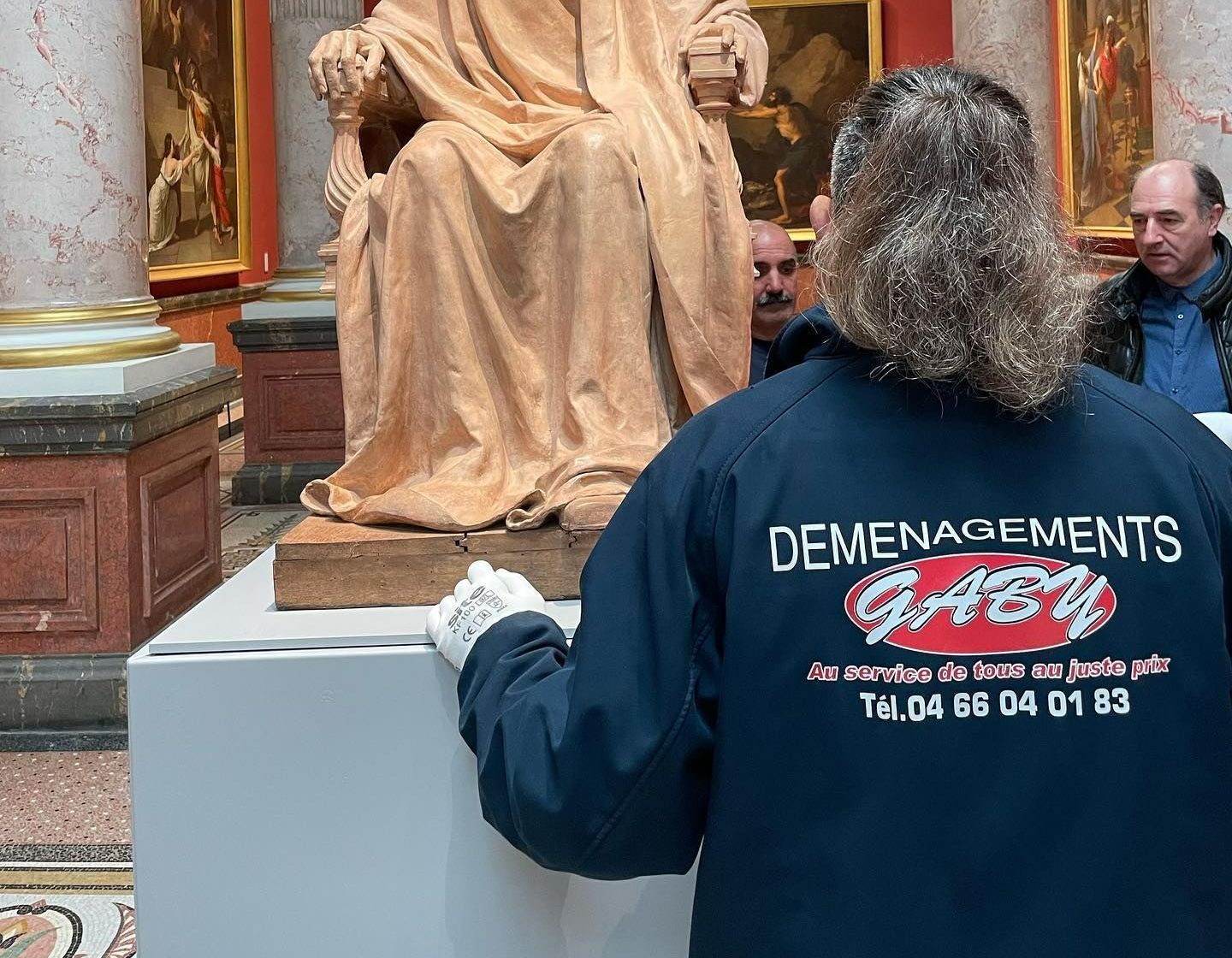 Homme vu de dos  dans un musée avec un blouson de déménagements Gaby