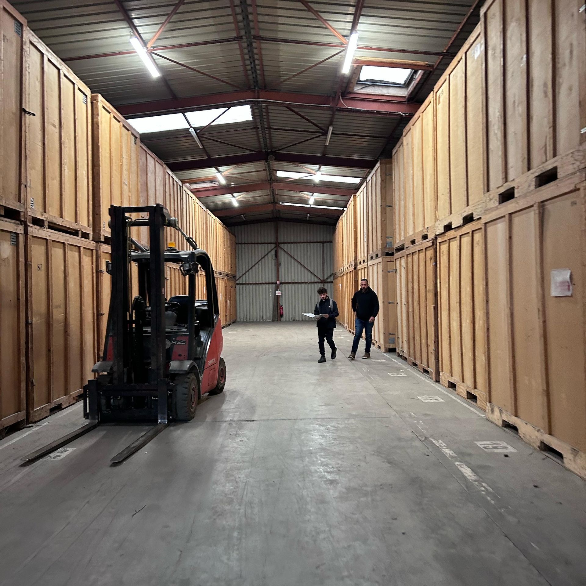 Deux personnes et un manitou dans un bâtiment de stockage