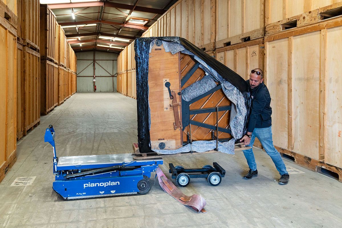 Employé de déménagement Gaby entrain de charger un piano sur un piano plan