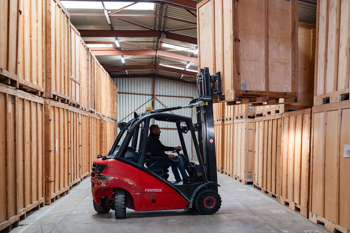 Homme qui prend un conteneur de garde-meuble avec son Manitou