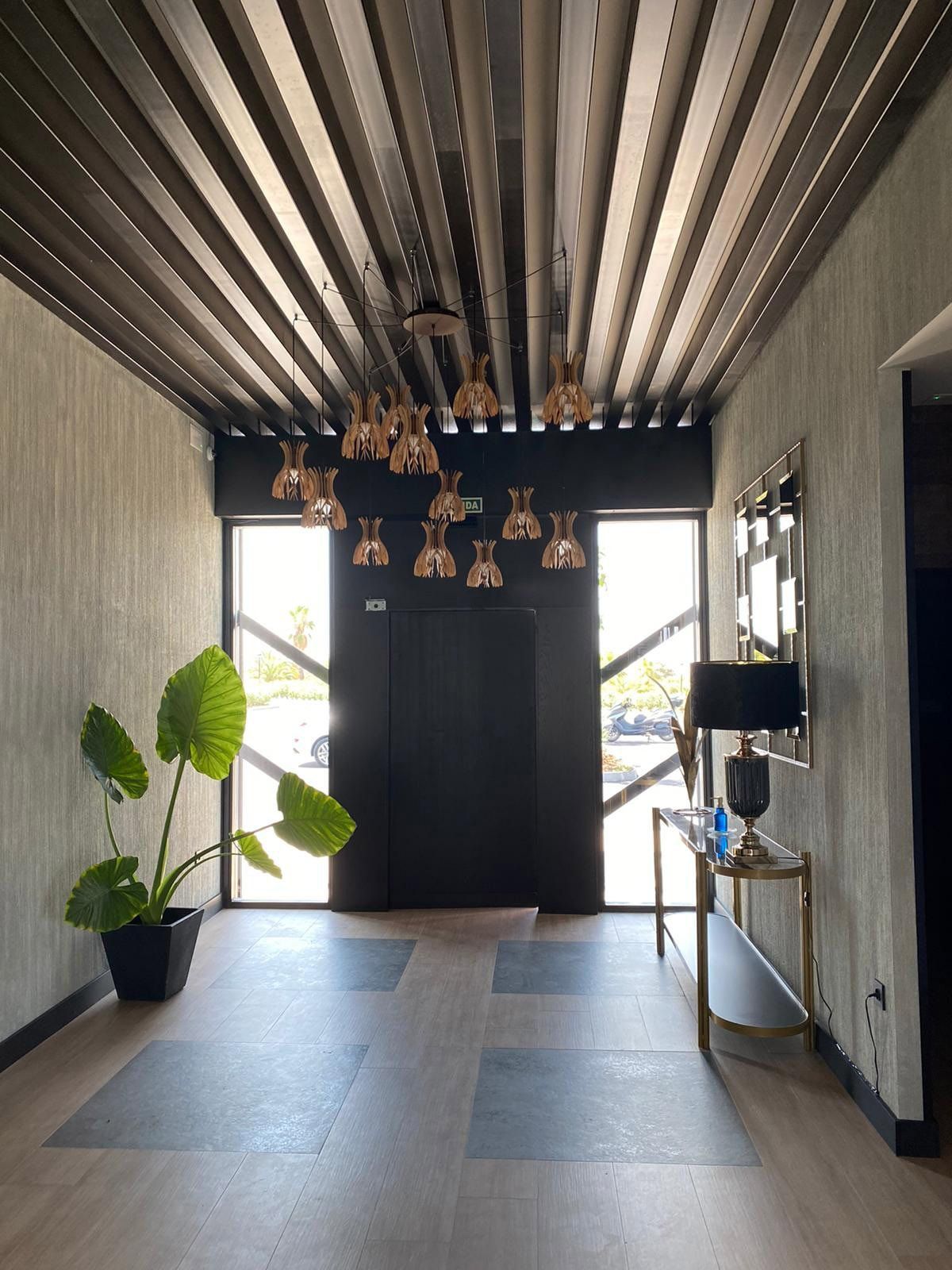 Un pasillo con un techo del que cuelgan muchas luces.