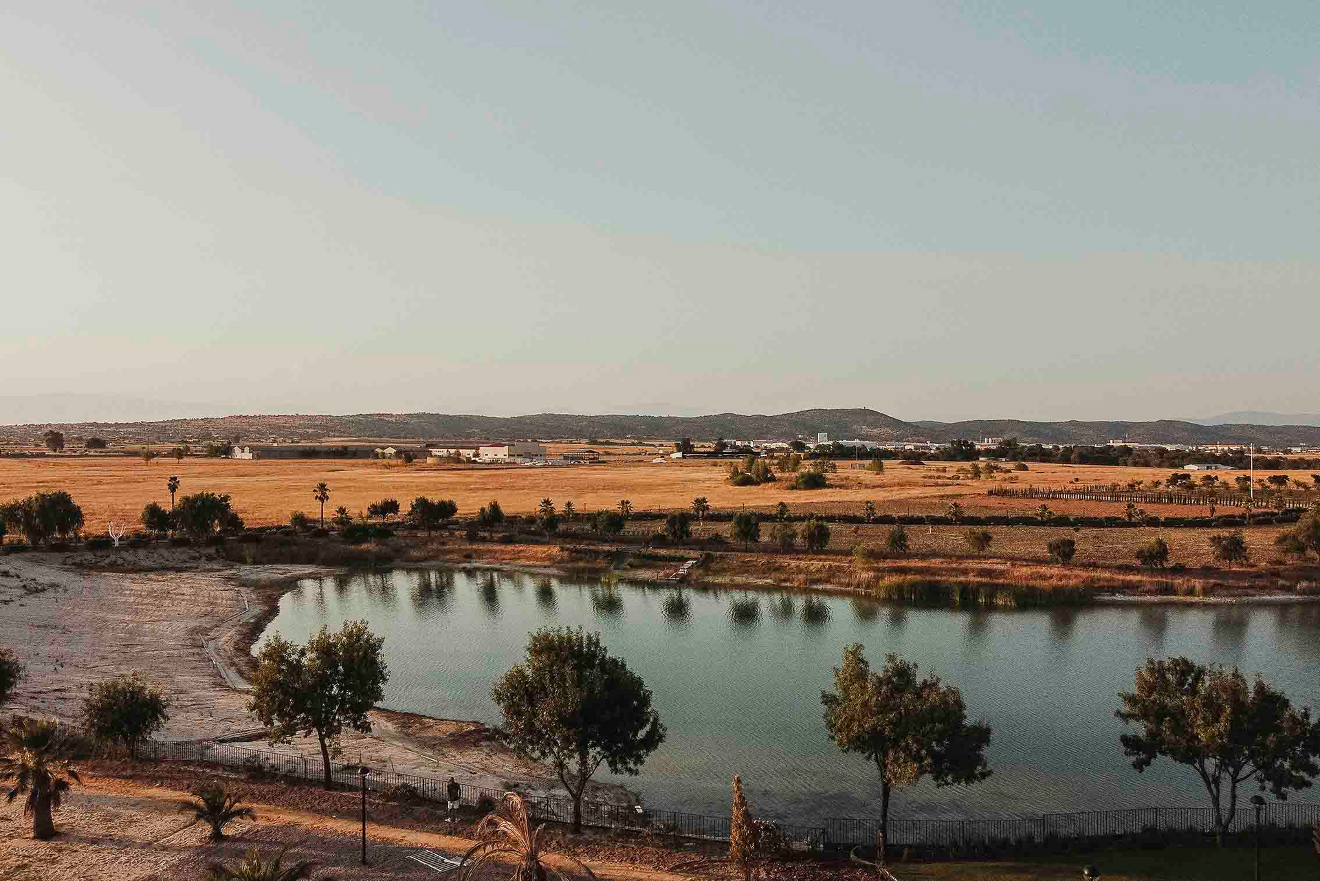 Una vista aérea de un lago rodeado de árboles y campos.