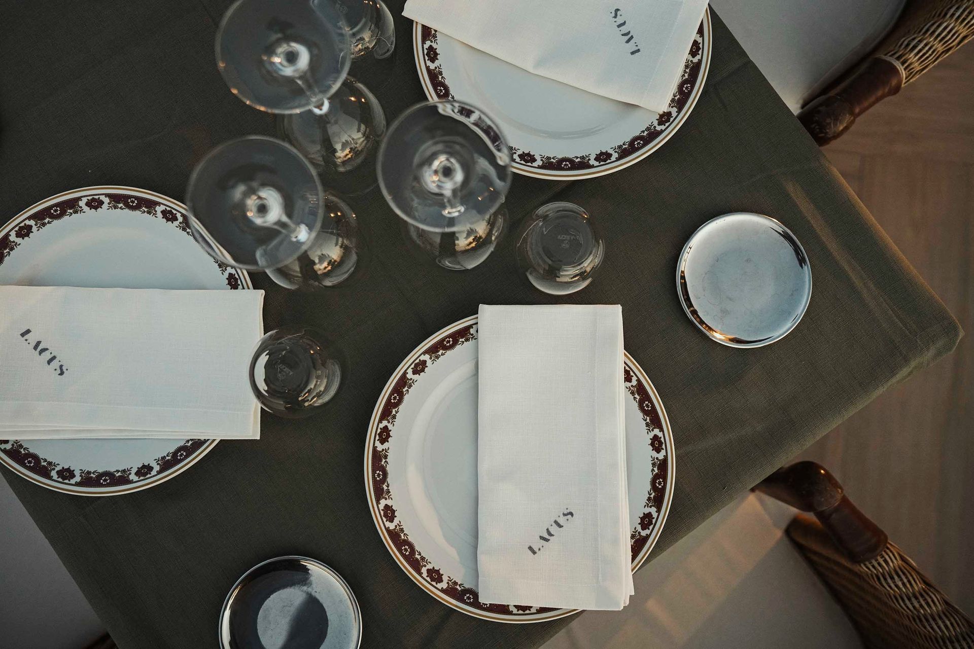 Platos y vasos sobre una mesa con una servilleta que dice Louis