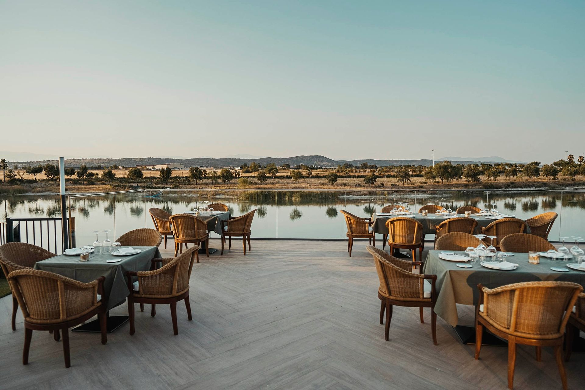 Un restaurante con mesas y sillas con vistas a un lago.