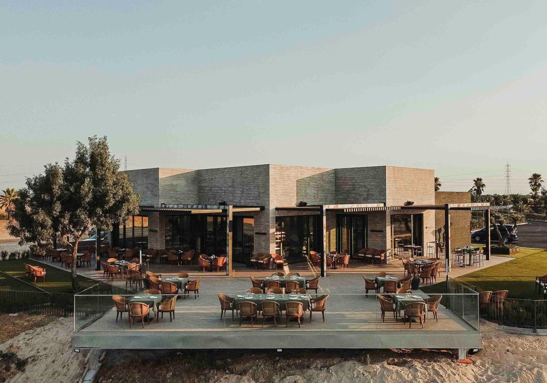 Una vista aérea de un restaurante con mesas y sillas delante de él.