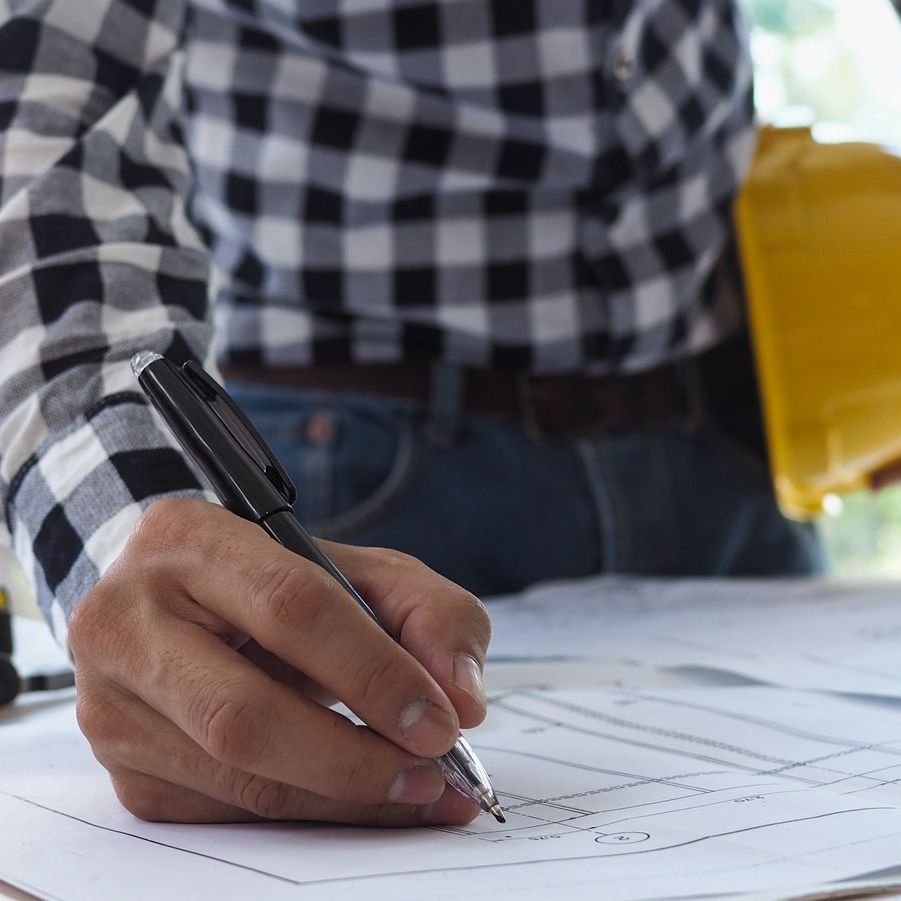 Maitre d'œuvre qui ecrit sur un plan