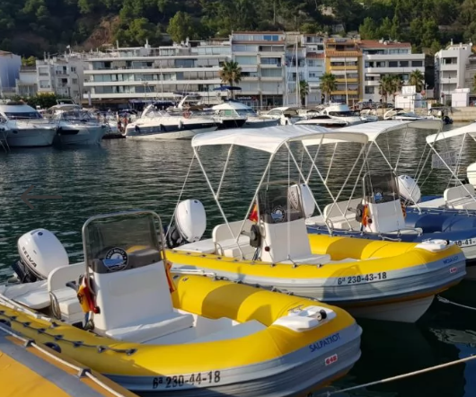 Una fila de barcos amarillos y blancos están atracados en un puerto