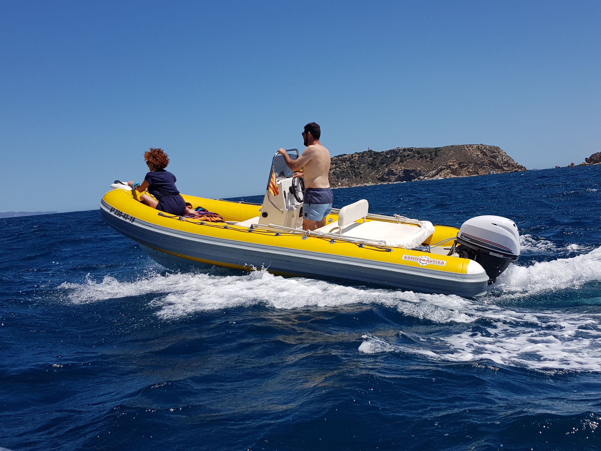 Un hombre conduce un barco amarillo en el océano.