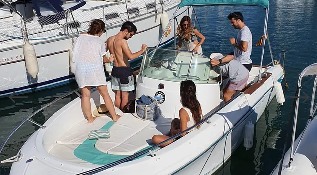 Un grupo de personas está de pie en un bote en el agua.