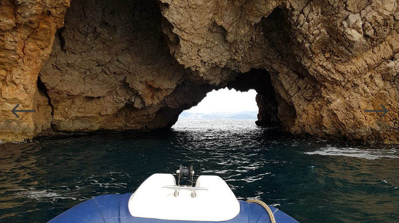 Un barco está pasando por una cueva en el océano.