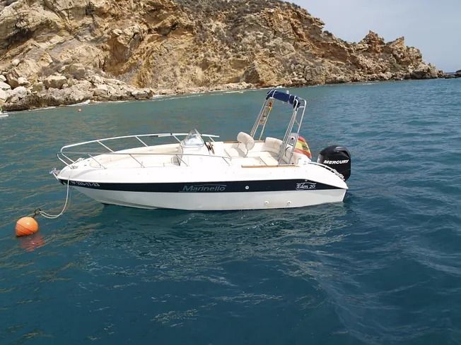 Un pequeño barco blanco flota sobre un cuerpo de agua.