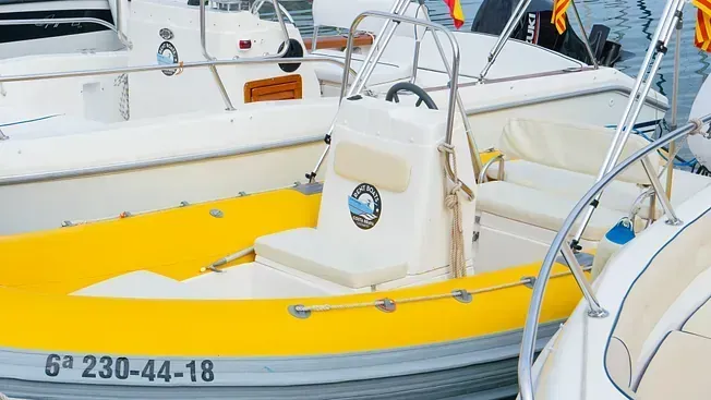 Un barco amarillo y blanco está atracado junto a un barco blanco.
