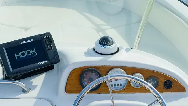 Un barco con un volante y un gps en el tablero.